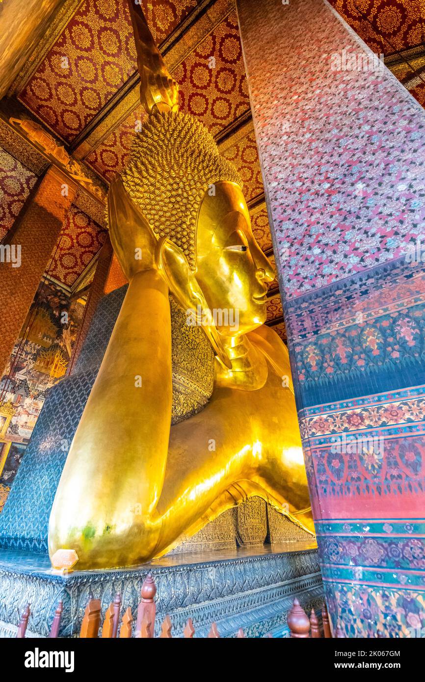 Belle statue de Bouddha couché en or placée dans le temple Wat Pho, Bangkok. Lieu spirituel de la religion du bouddhisme avec de belles ornements sur le pi Banque D'Images