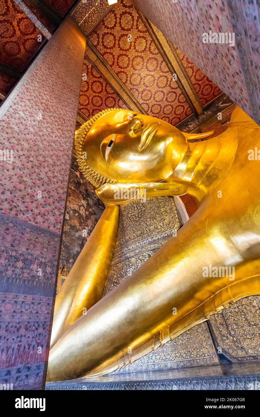 Belle statue de Bouddha couché en or placée dans le temple Wat Pho, Bangkok. Lieu spirituel de la religion du bouddhisme avec de belles ornements sur le pi Banque D'Images