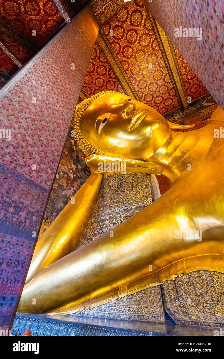 Belle statue de Bouddha couché en or placée dans le temple Wat Pho, Bangkok. Lieu spirituel de la religion du bouddhisme avec de belles ornements sur le pi Banque D'Images