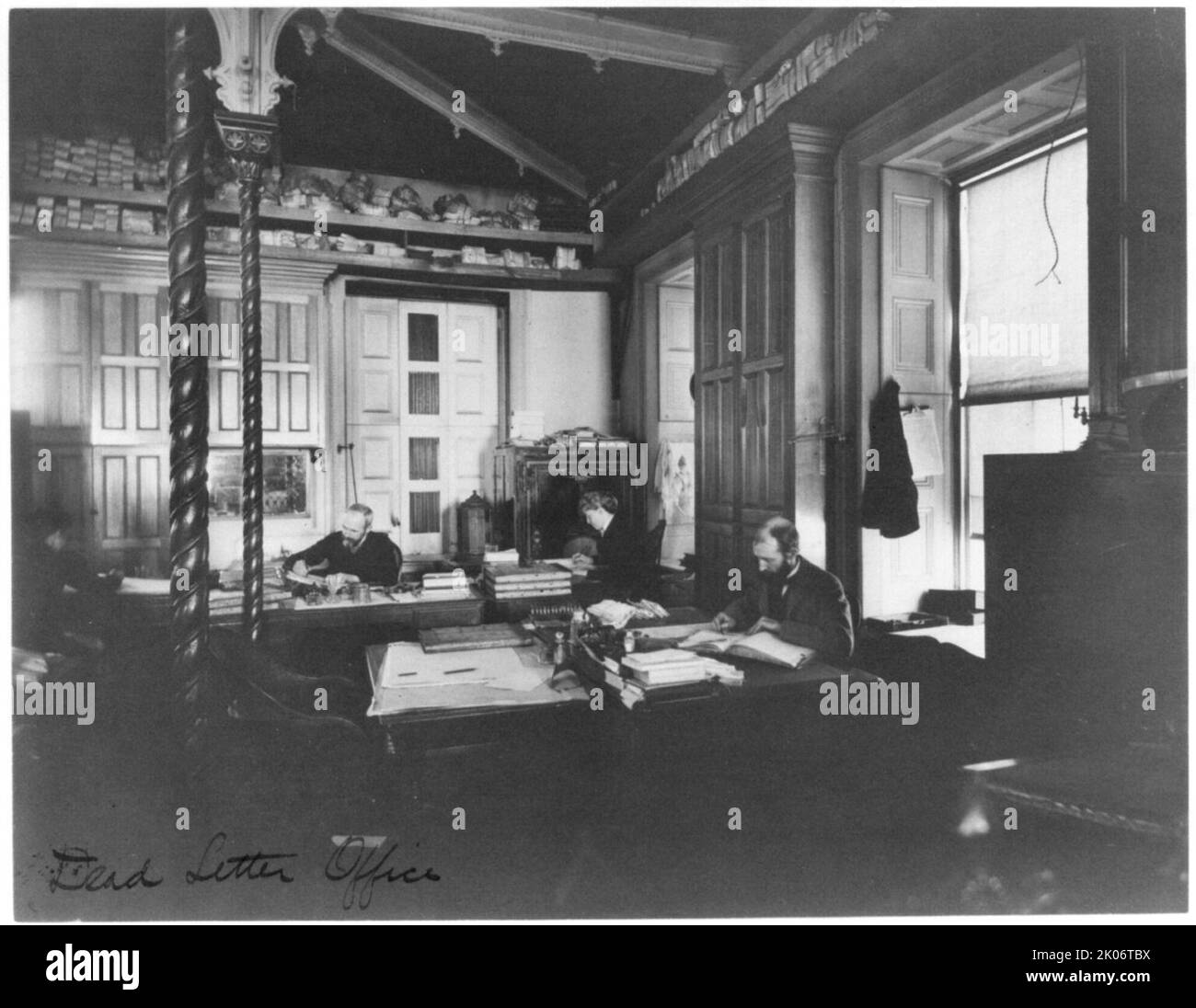 Service des postes - Bureau de la lettre morte, entre 1890 et 1950. Deux hommes et une femme travaillant au bureau. Banque D'Images
