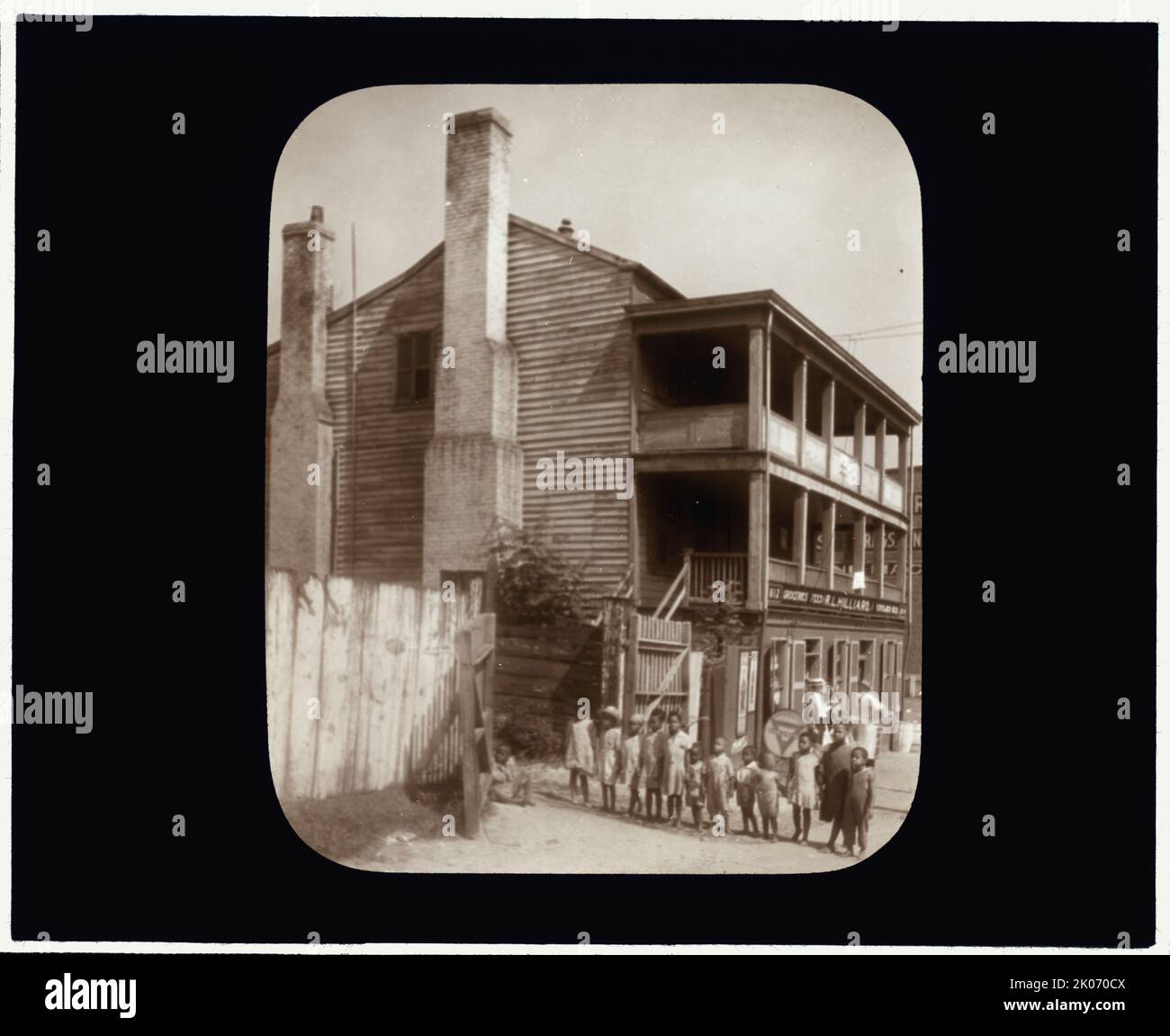 Ancienne taverne, Brook Road, Richmond, Virginie, entre c1930 et 1939. Douze enfants afro-américains debout dans une rangée près d'un bâtiment en bois de trois étages. Panneau à l'avant: Épicerie ... VALEUR Hilliard ... Banque D'Images