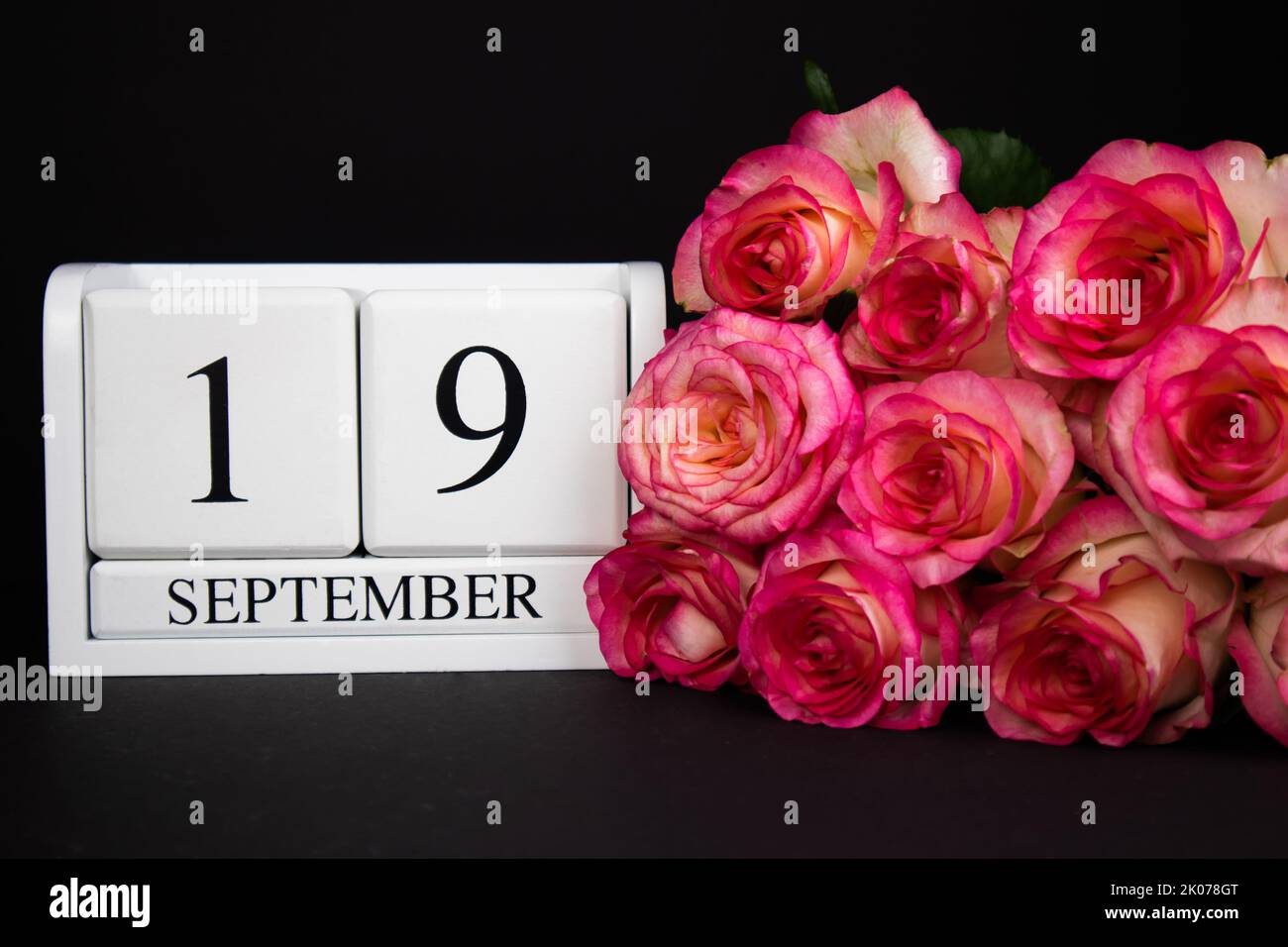19 septembre calendrier en bois, blanc sur fond noir, roses se trouvent à proximité Banque D'Images