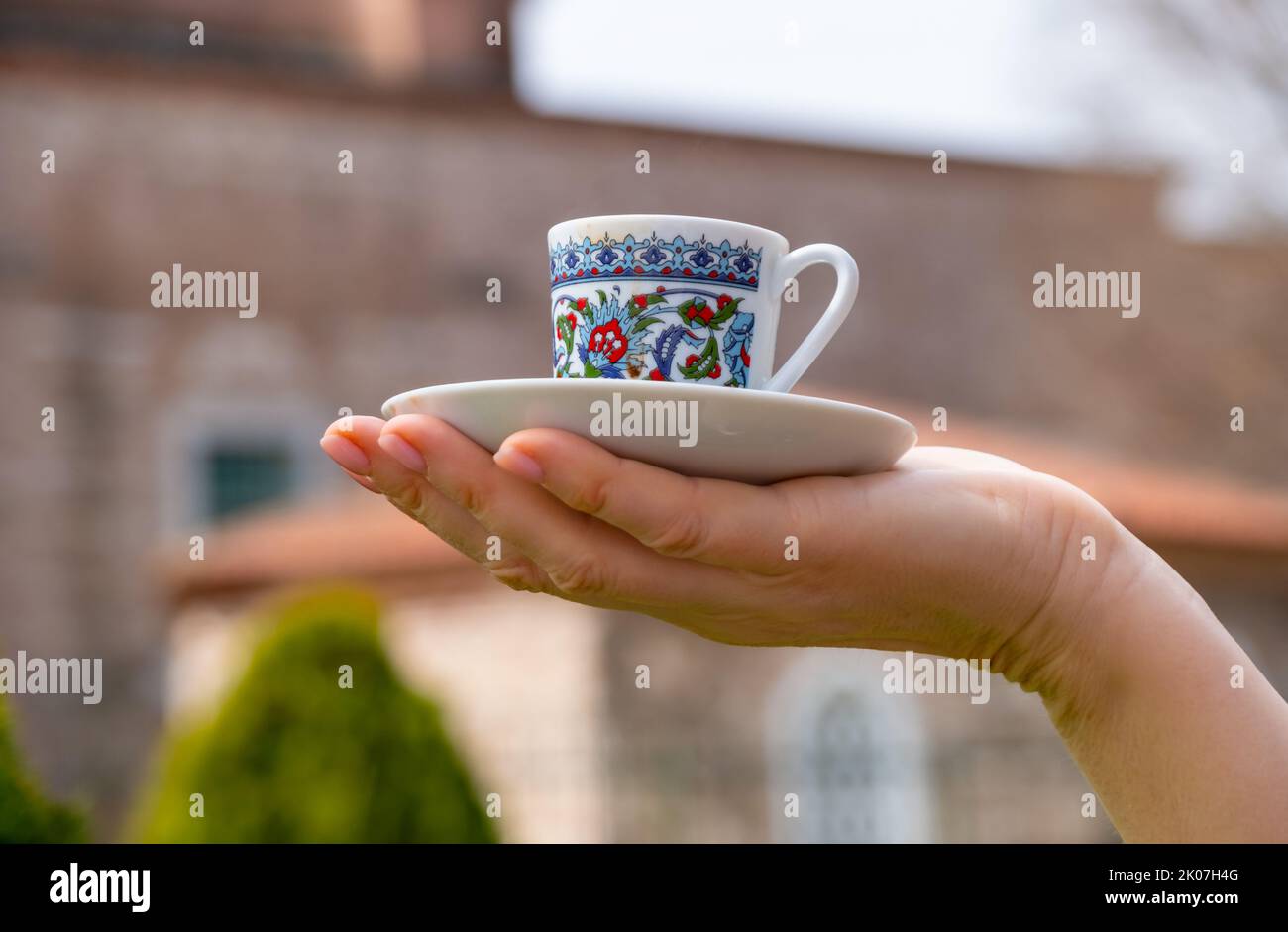 Une tasse de café turc sur la paume, sur fond d'architecture turque traditionnelle Banque D'Images