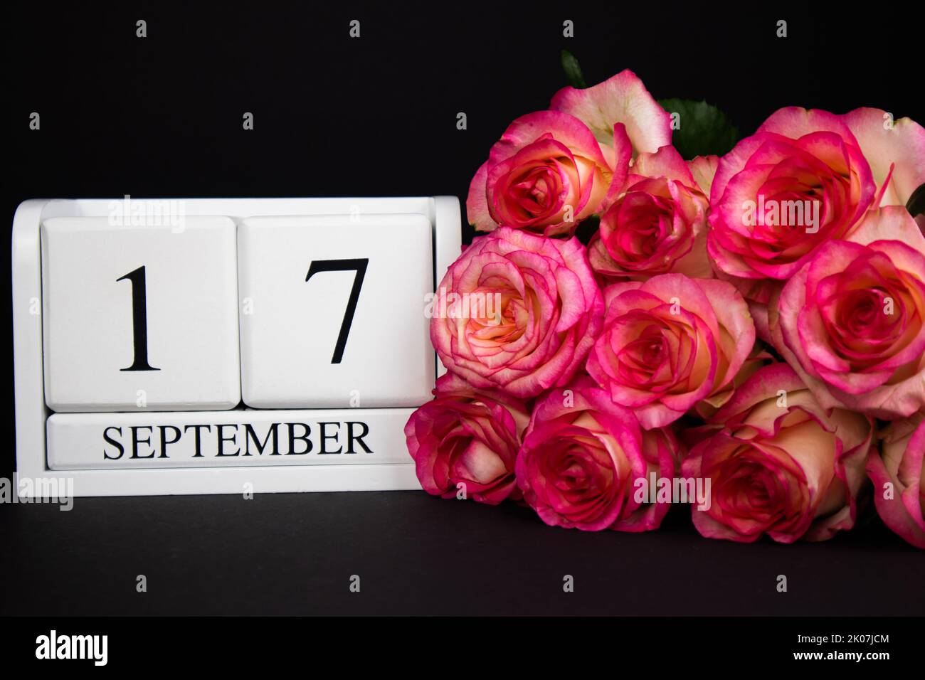 17 septembre calendrier en bois, blanc sur fond noir, roses se trouvent à proximité Banque D'Images