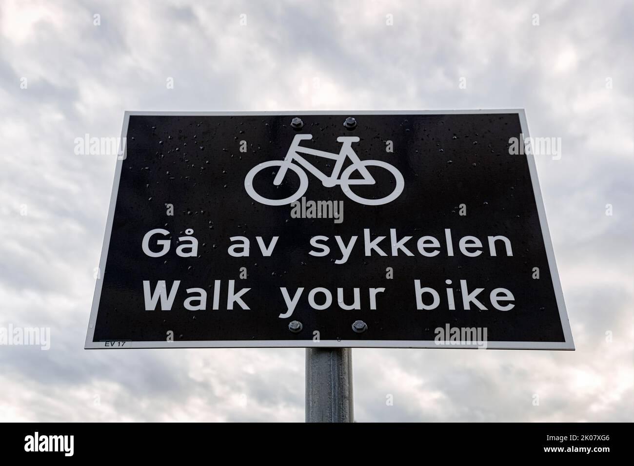 Panneau de signalisation noir et blanc, bilingue avec pictogramme vélo et inscription pousser votre vélo, faire descendre les cyclistes, Norvège Banque D'Images