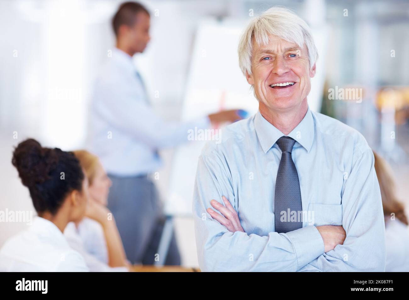 Homme d'affaires avec élégance. Portrait de l'élégant homme d'affaires senior souriant avec des cadres en arrière-plan. Banque D'Images