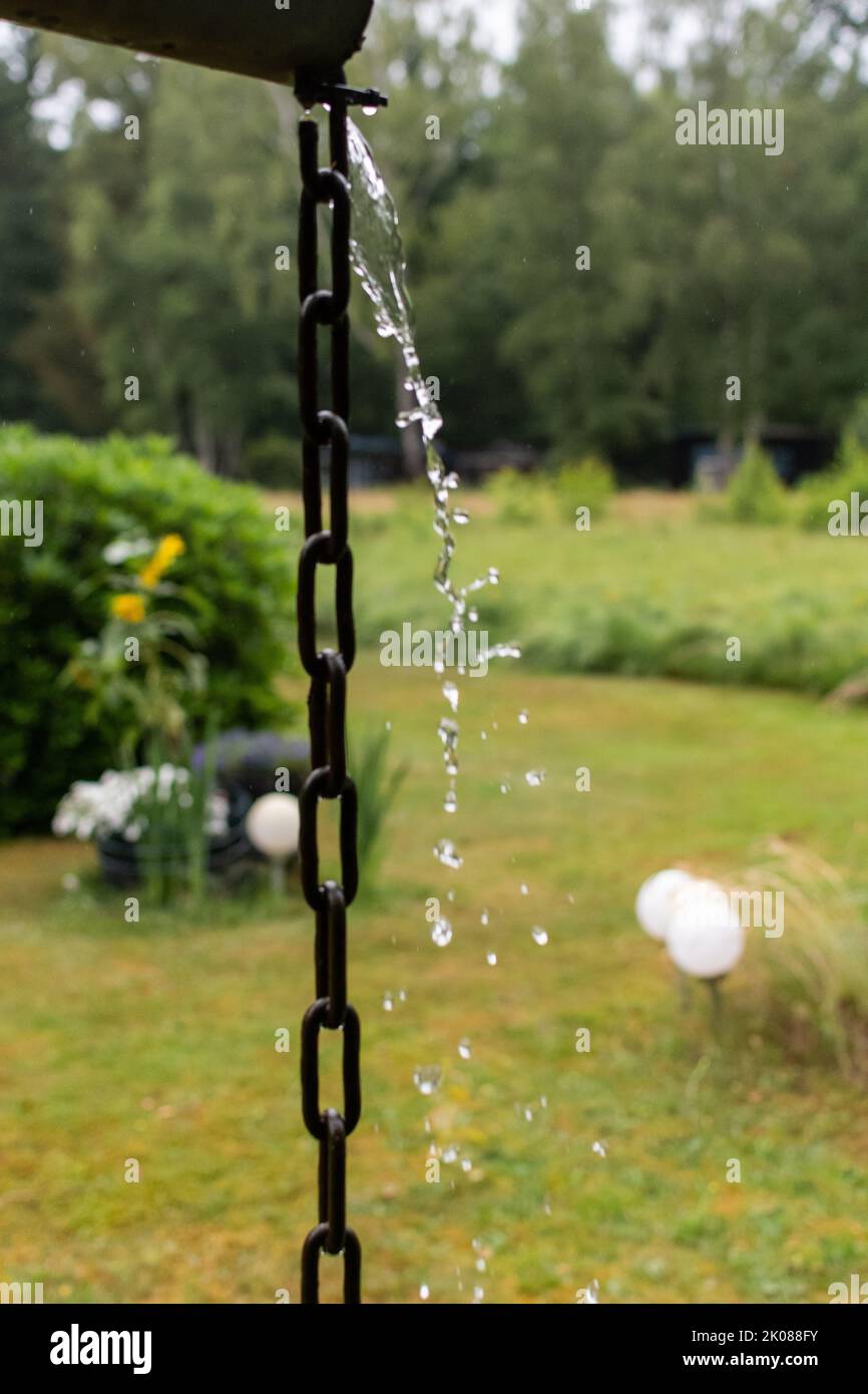 l'eau s'étend vers le bas d'une chaîne penchée d'une gouttière Photo Stock  - Alamy