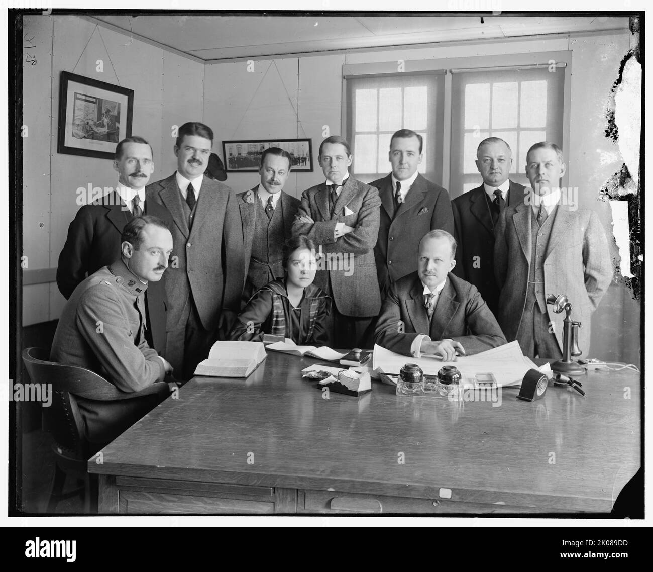 B. Clarkson et amp; groupe, entre 1910 et 1920. Femme et groupe d'hommes regardant les plans architecturaux. L'auteur et publiciste AMÉRICAIN Grosvenor B. Clarkson (au centre, avec les armes pliées) était directeur du Conseil de la Défense nationale pendant la première Guerre mondiale Banque D'Images