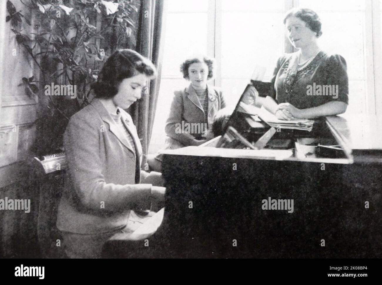 La princesse Elizabeth joue le piano comme sa mère, la reine Elizabeth, et sa sœur, la princesse Margaret, regardent Banque D'Images