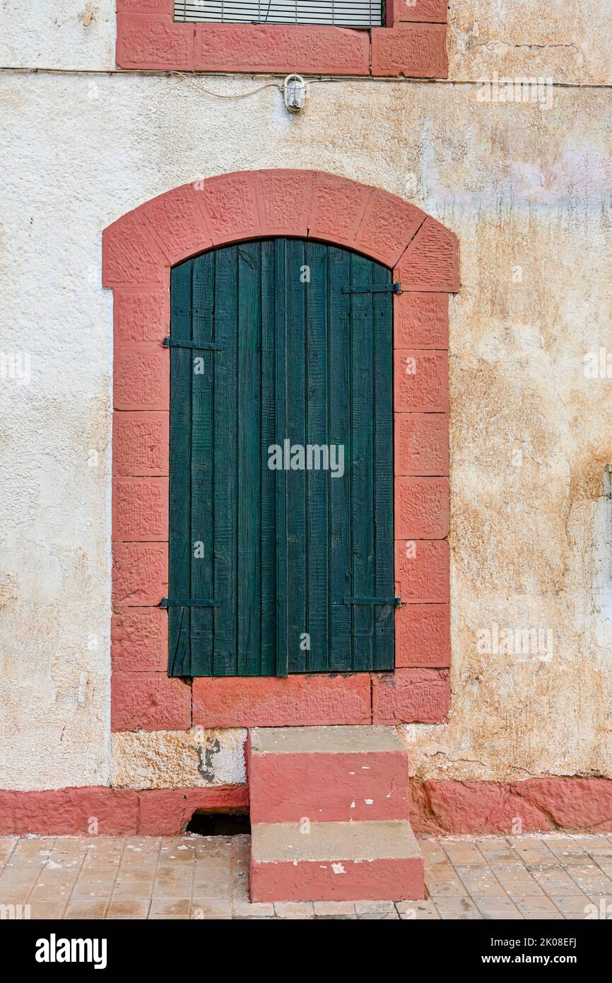 Porte en bois avec cadre en pierre peint rose. Banque D'Images