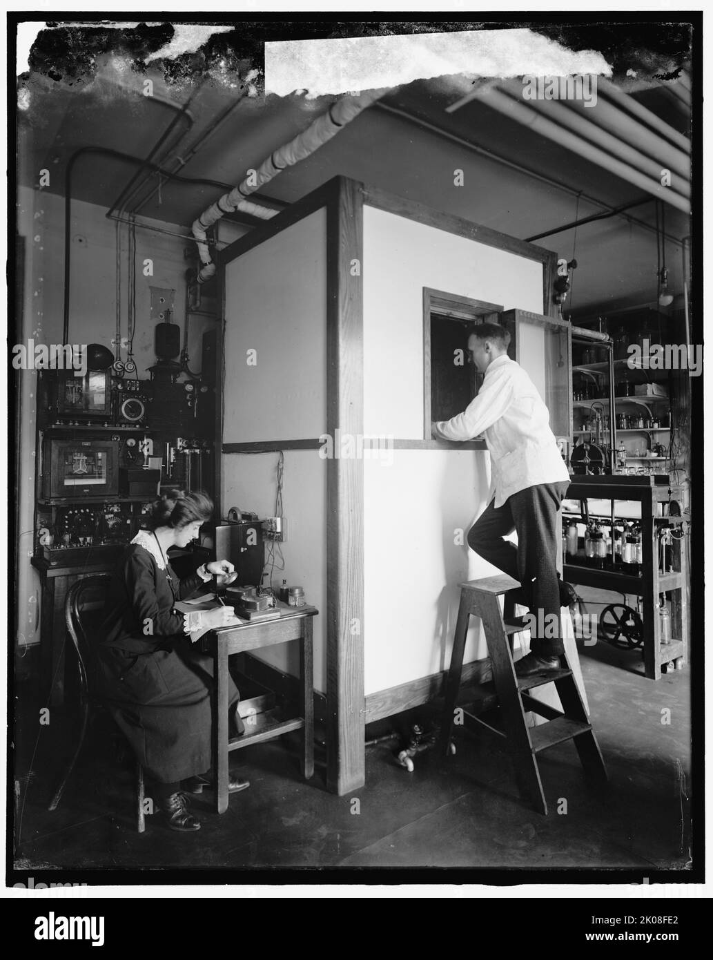 Home Economics Section, entre 1910 et 1920. ÉTATS-UNIS. Homme et femme avec appareil scientifique. Banque D'Images
