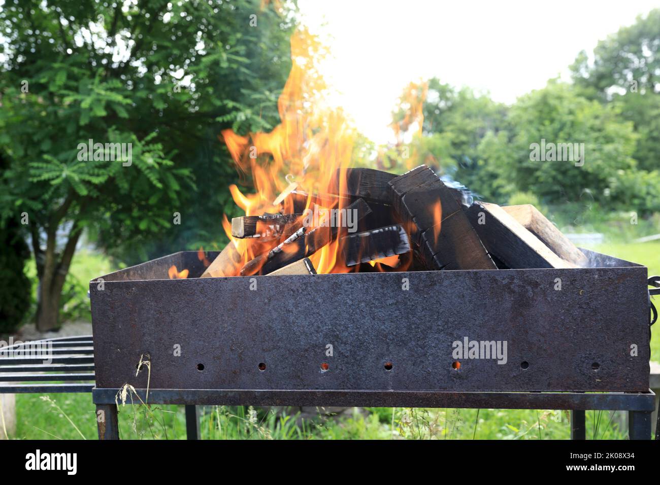 Vue sur le bois de chauffage en feu dans le grill dans l'arrière-cour Banque D'Images