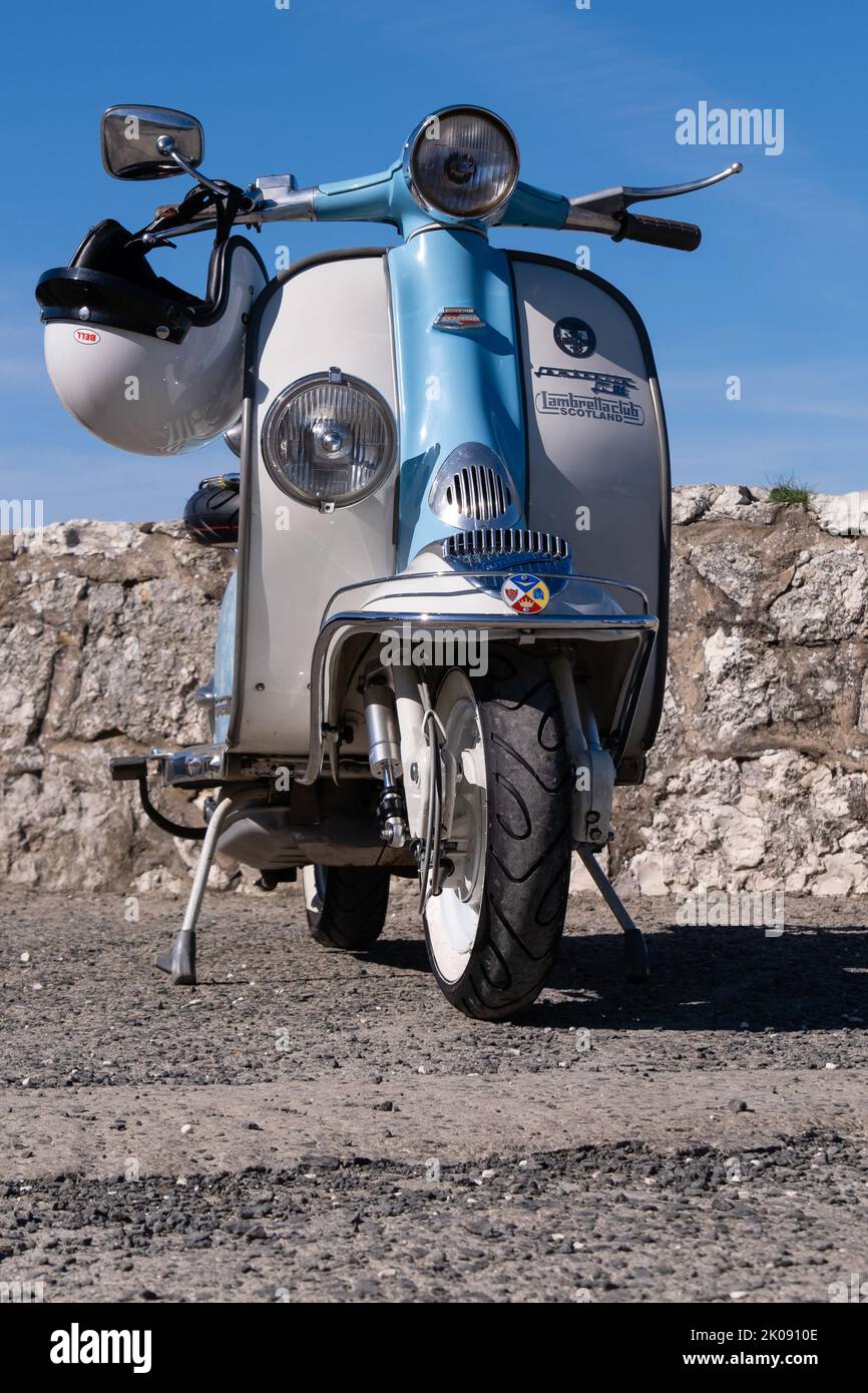 Vintage Li bicolore bleu et blanc Lambretta scooter garé avec casque de crash blanc sur le guidon. Ballintoy, Royaume-Uni - 10 septembre 2022. Banque D'Images