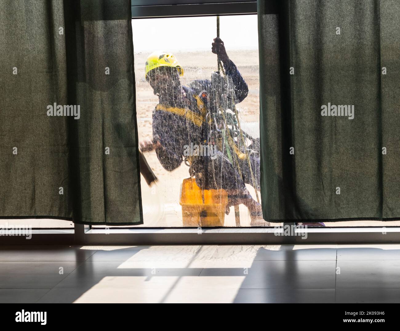 Silhouette d'un nettoyant pour vitres à accès par corde fonctionnant en hauteur. Banque D'Images