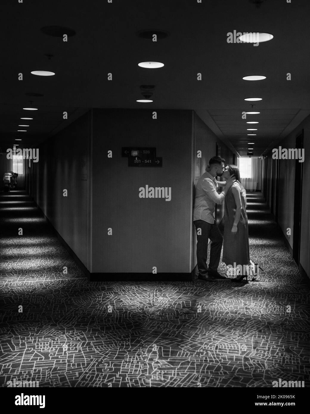 Couple amoureux debout et embrassant dans le couloir de l'hôtel Banque D'Images