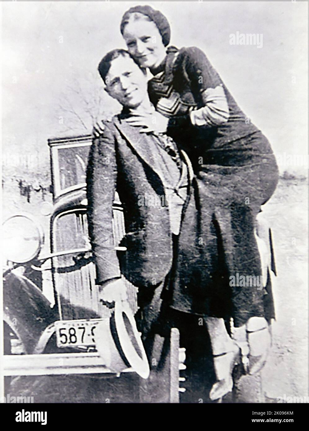 Bonnie et Clyde. Bonnie Elizabeth Parker (1 octobre 1910 - 23 mai 1934) et Clyde Chestnut Barrow (24 mars 1909 - 23 mai 1934) étaient un couple criminel américain qui a voyagé dans le centre des États-Unis avec leur gang pendant la Grande Dépression, connu pour leurs vols bancaires, bien qu'ils aient préféré voler de petits magasins ou des maisons funéraires rurales. Leurs exploits ont capté l'attention de la presse américaine et de son lectorat pendant ce qui est parfois appelé l'« ère de l'ennemi public » entre 1931 et 1934. Banque D'Images