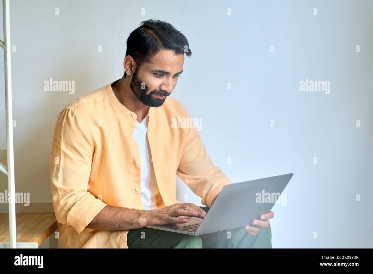 Utilisateur indien assis à la maison tapant sur l'ordinateur portable à l'aide d'un ordinateur. Banque D'Images