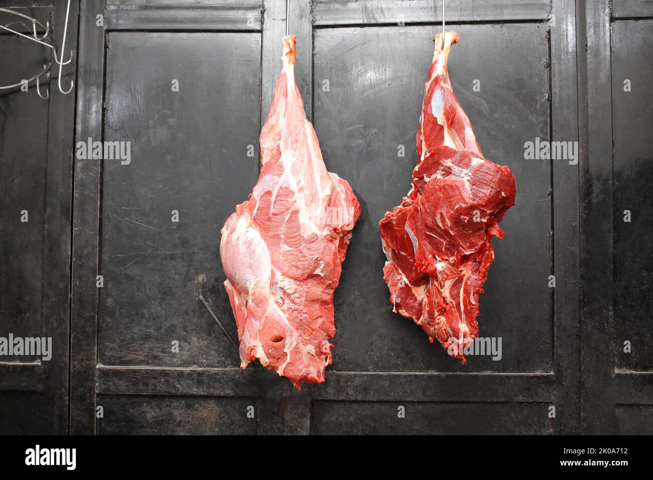 Bœuf fraîchement coupé suspendu dans une boucherie – viande crue pour des coupes de haute qualité Banque D'Images