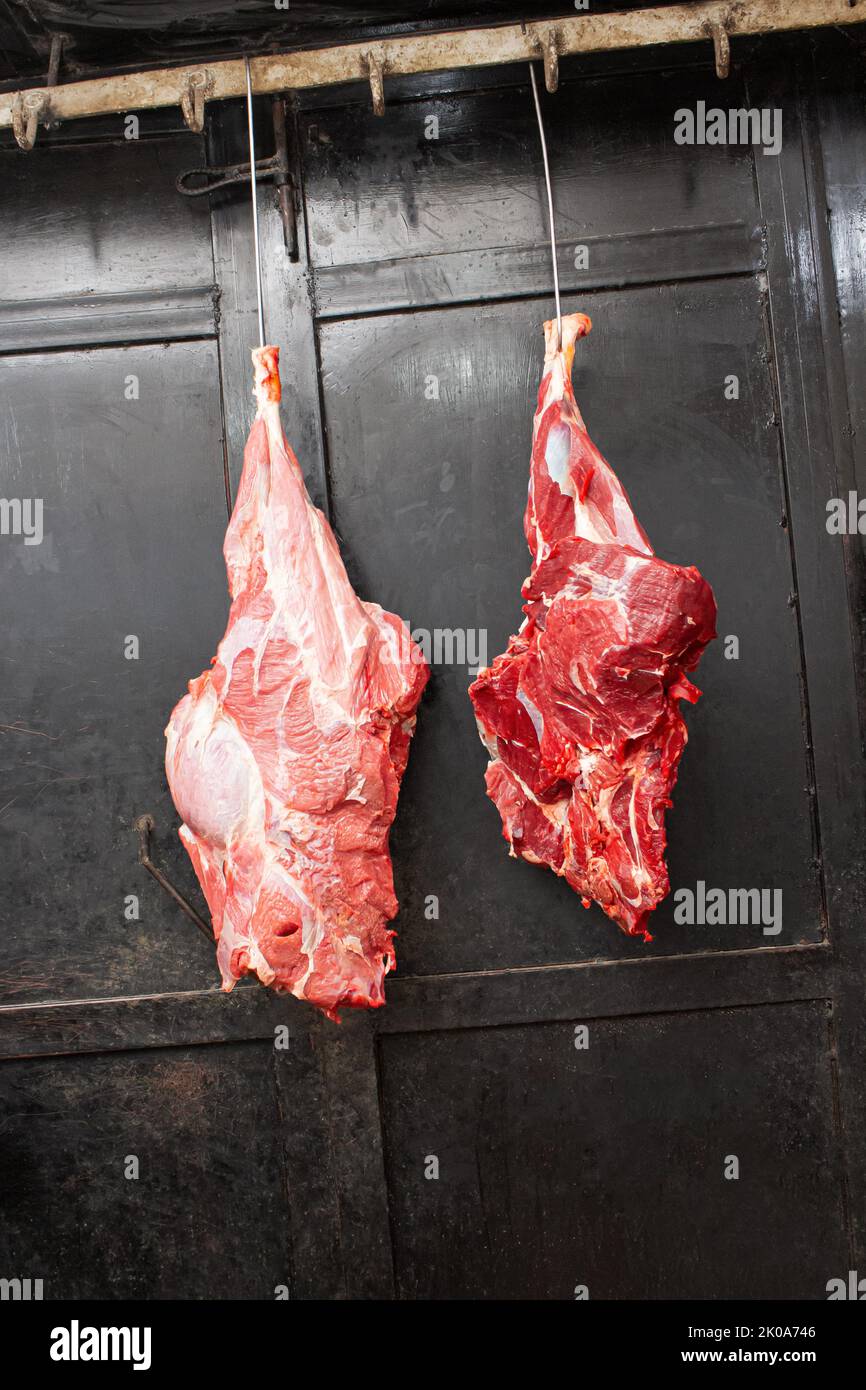 Bœuf fraîchement coupé suspendu dans une boucherie – viande crue pour des coupes de haute qualité Banque D'Images