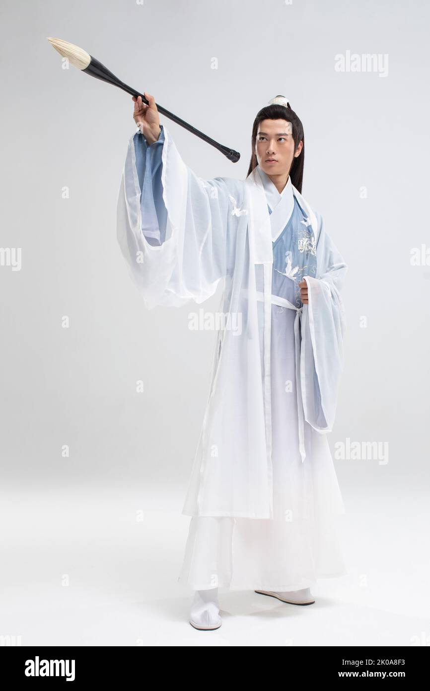 Jeune homme chinois en costume antique écrivant la calligraphie Banque D'Images