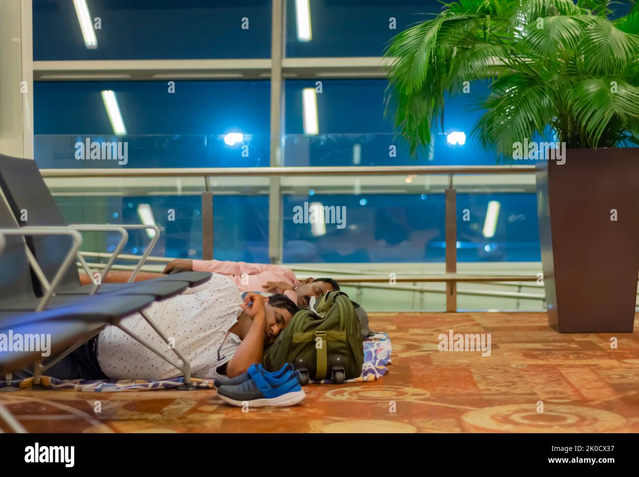 Les voyageurs fatigués et fatigués dormant au sol de l'aéroport international Indira Gandhi, en attendant de prendre un vol de correspondance. Banque D'Images