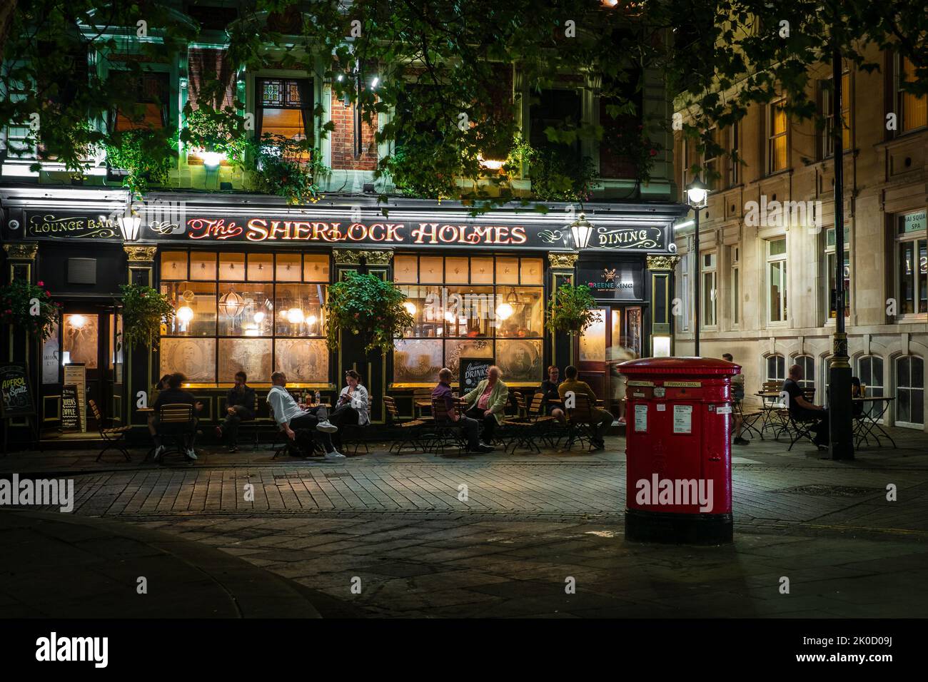 Le pub historique du centre de Londres, le Sherlock Holmes, illuminé lors d'une soirée d'été sombre Banque D'Images