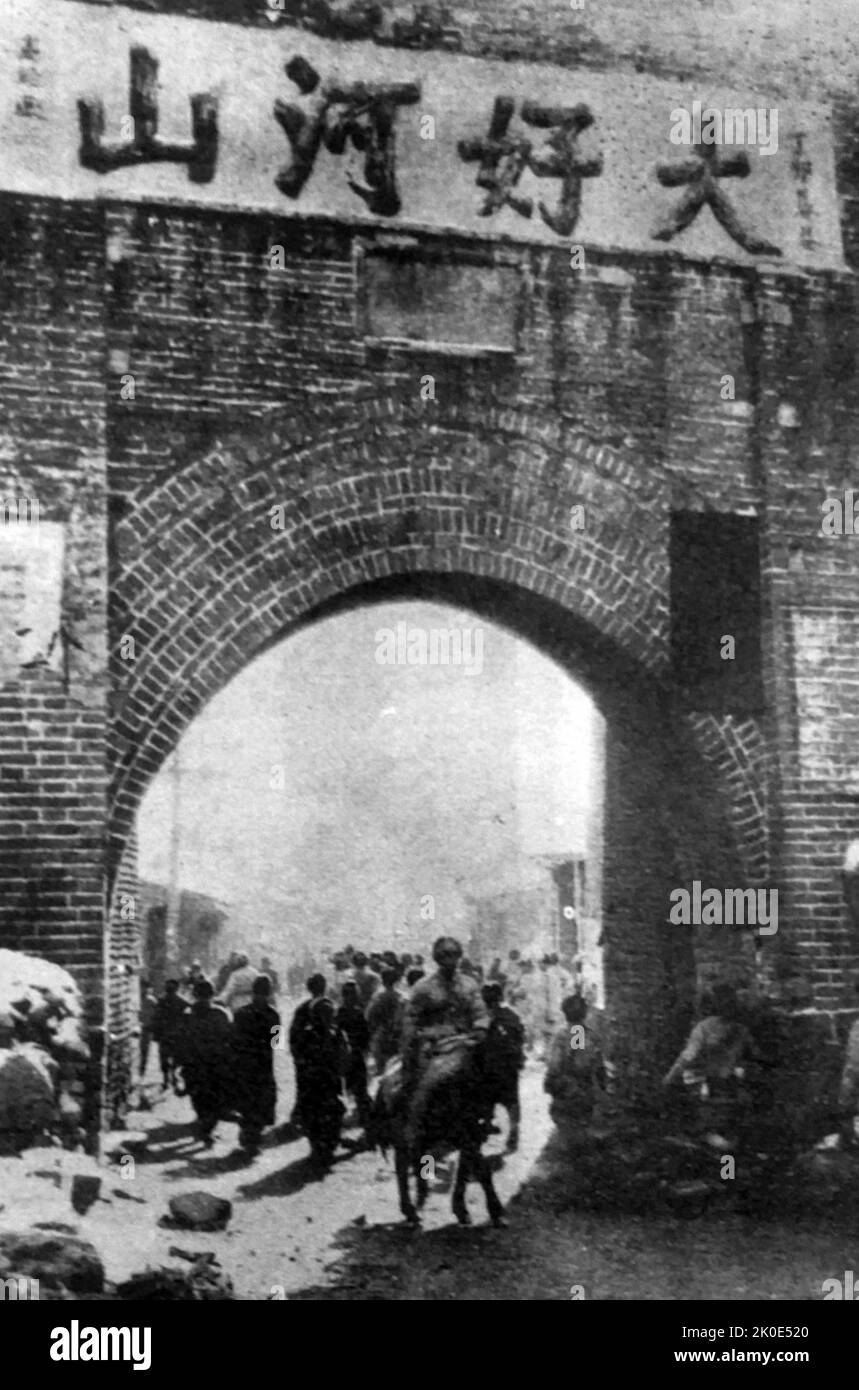 Armée de libération du peuple chinois, entrant dans les dajingmen de Zhangjiakou, Hebei, 24 décembre 1948. « Great Rivers and mountains » est écrit au-dessus de la porte de la ville. Banque D'Images