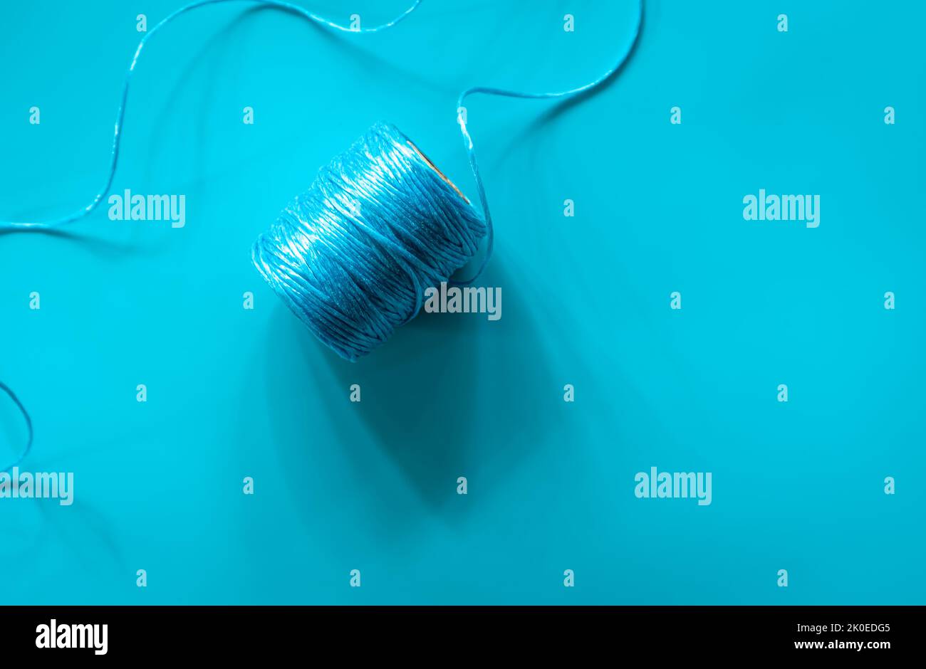 Une boule de fils bleus sur fond bleu, plat. Banque D'Images