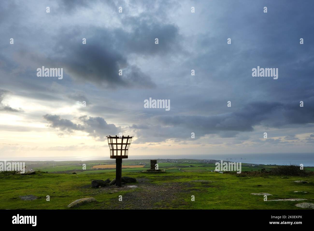 Le feu à éclats au sommet de la chapelle Carn Brea, Cornwall, avec vue sur l'Atlantique - John Gollop Banque D'Images