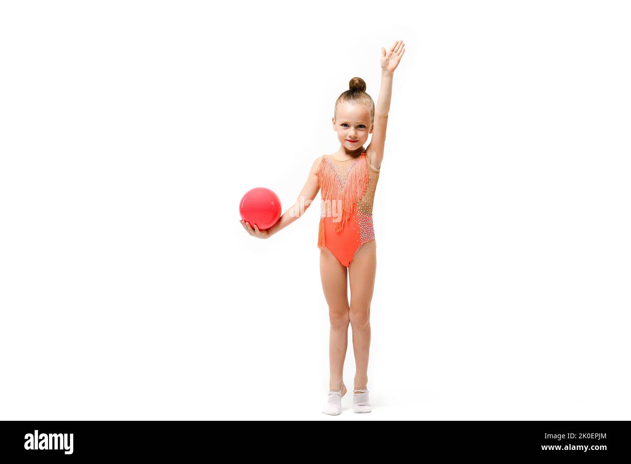 Petite fille artistique Gymnast acrobatics avec boule de caoutchouc restez sur toute la longueur à l'arrière-plan isolé de studio dans le léopard de fête brillant. Une main est levée u Banque D'Images