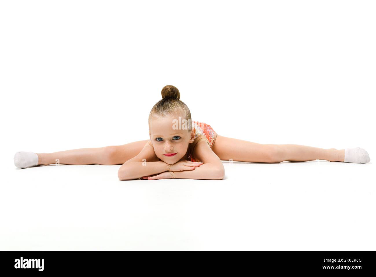 Petite fille souriante, danseuse de gymnaste, danseuse d'acrobatie avec des jambes en fentes, sport professionnel et enfants, arrière-plan isolé Banque D'Images