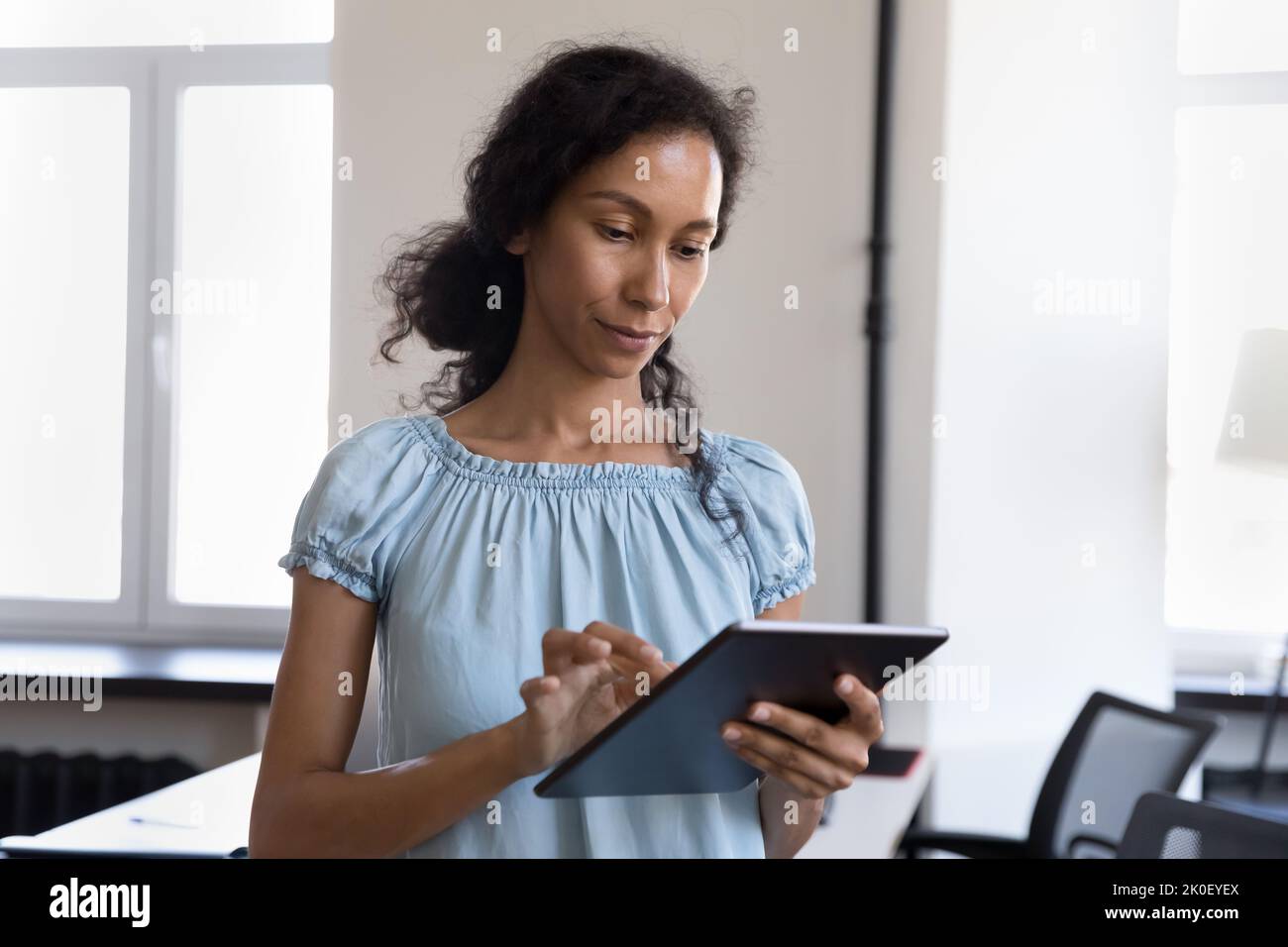 Une jeune femme africaine sérieuse utilisant une application en ligne professionnelle Banque D'Images