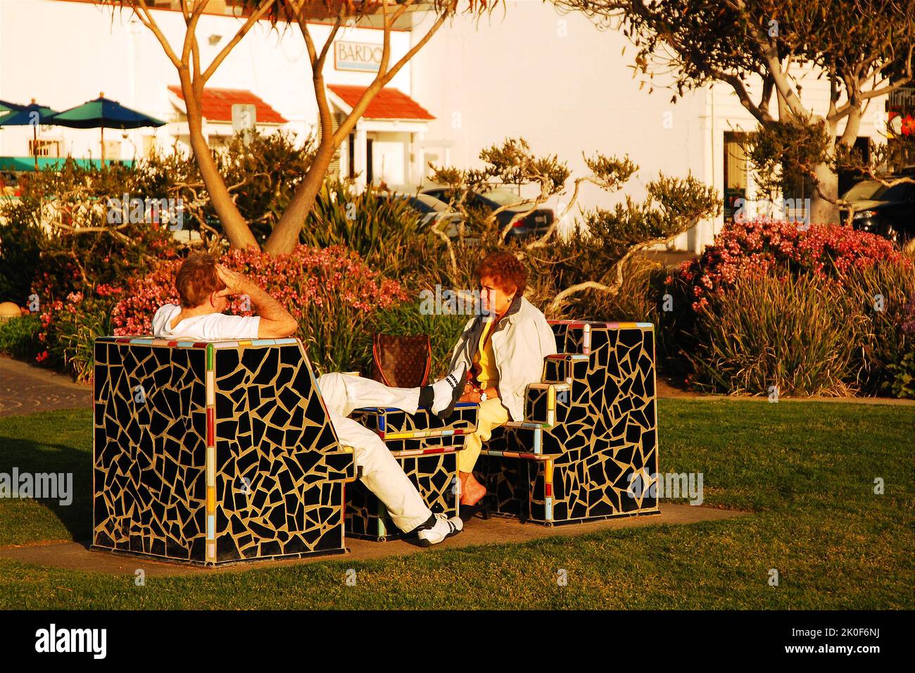 Deux femmes adultes ont une conversation dans des chaises artistiques et élégantes près du rivage à Laguna Beach, Californie Banque D'Images