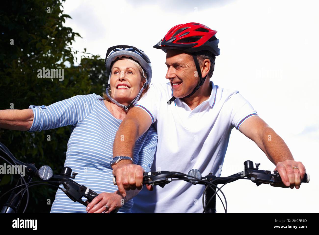 Sportif homme et femme matures à vélo par une journée ensoleillée. Portrait d'un homme et d'une femme matures et sportifs à vélo par une journée ensoleillée. Banque D'Images