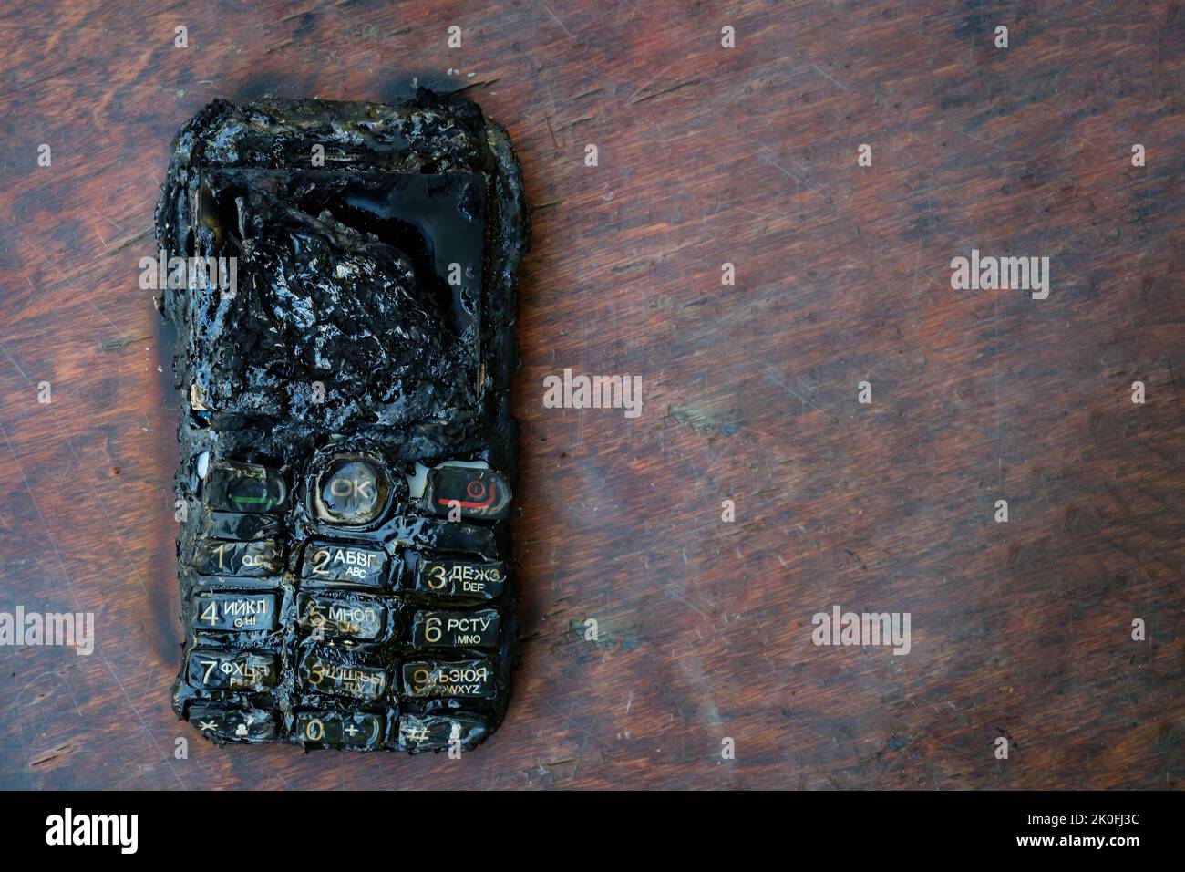 un téléphone portable brûlé se trouve sur la table Banque D'Images