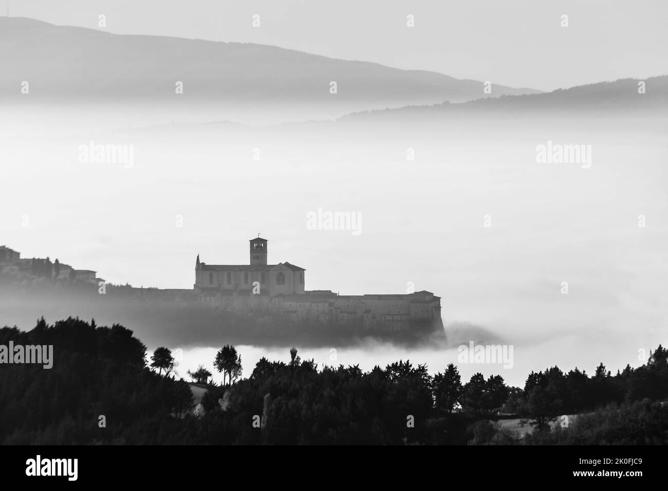 Vue sur l'église Saint françois Assise Ombrie Italie au-dessus d'une mer de brouillard Banque D'Images