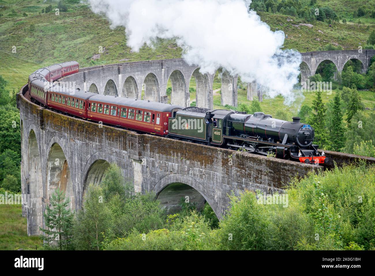 Glenfinnan,Inverness-shire,Scottish Highlands-21 juillet 2022:le conducteur du train fait des vagues et laisse de la vapeur aux spectateurs, comme le train emblématique, montré dans Harry P. Banque D'Images