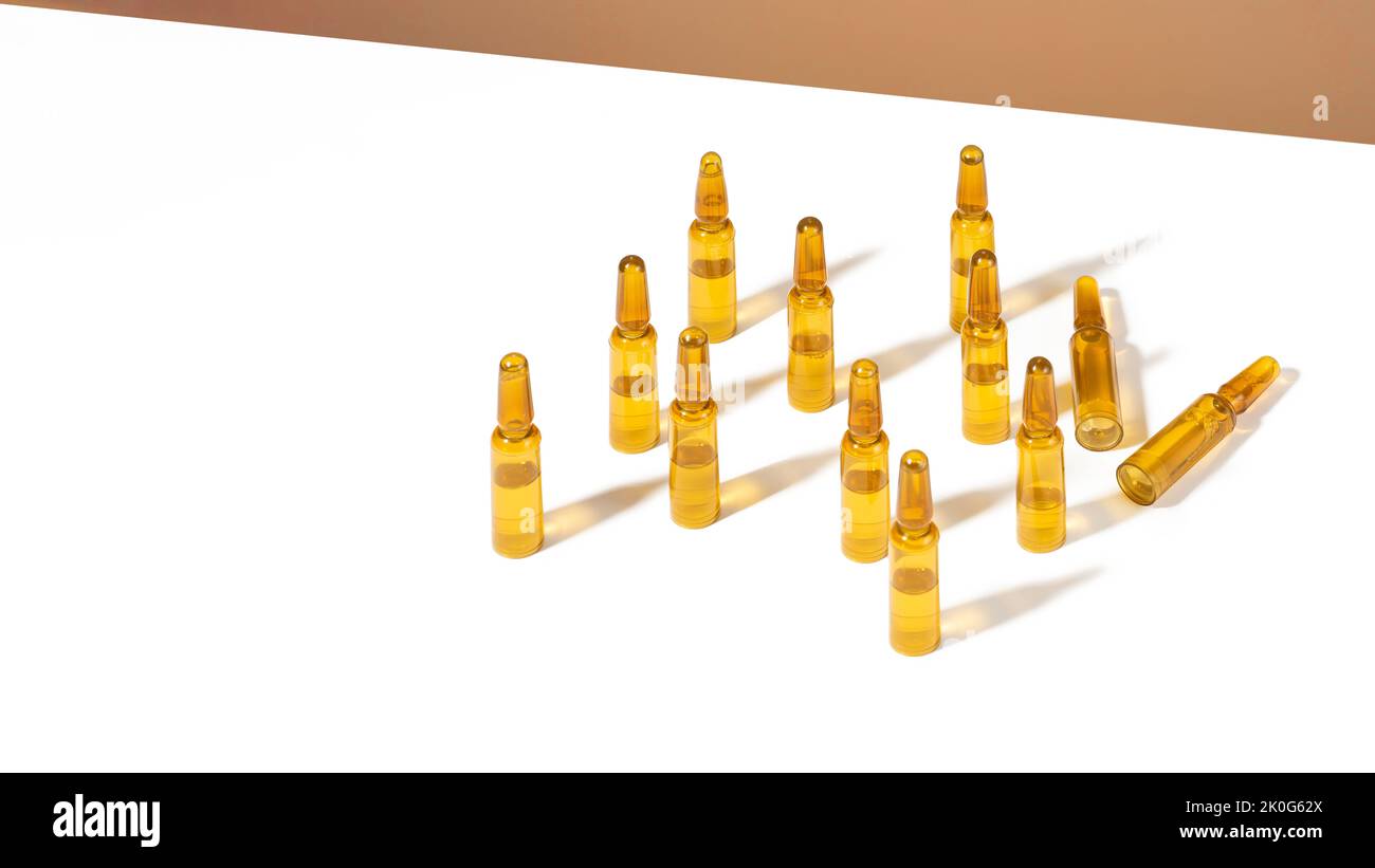 Grouper les ampoules cosmétiques avec du sérum sur fond blanc et marron avec des ombres et des caustiques. Soins de beauté pour les cheveux et la peau. Concept autosoins, bien-être Banque D'Images