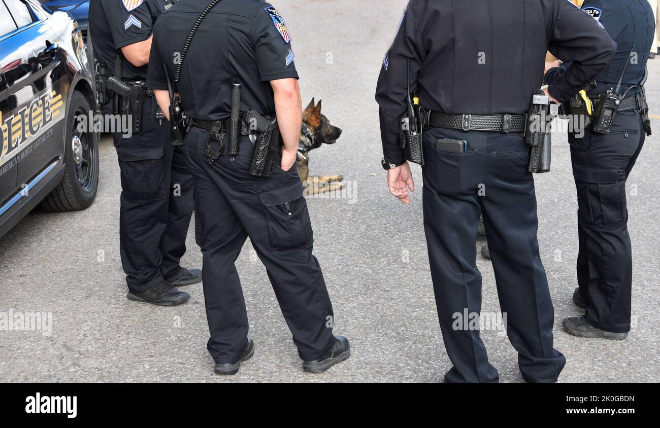 Des policiers et un chien de police se réunissent pour une réunion informelle lors d'un festival d'arts en plein air à Santa Fe, au Nouveau-Mexique. Banque D'Images