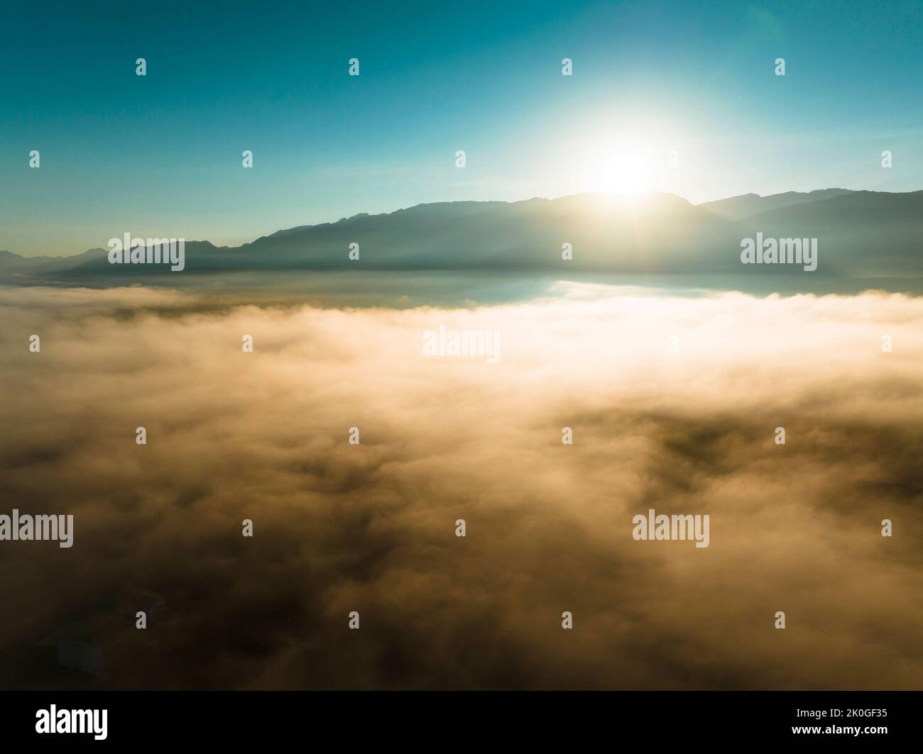 Vue aérienne des montagnes dans les nuages orange au lever du soleil été Banque D'Images