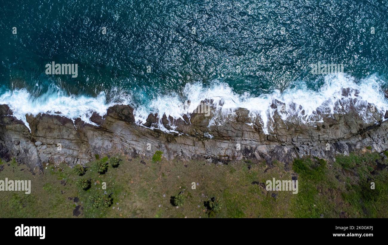 Vue aérienne des vagues de mer s'écrasant sur les rochers de la falaise dans l'océan bleu. Vue sur les rochers côtiers de l'océan de Phuket. Point de vue sur le paysage de Laem Phromthep Banque D'Images