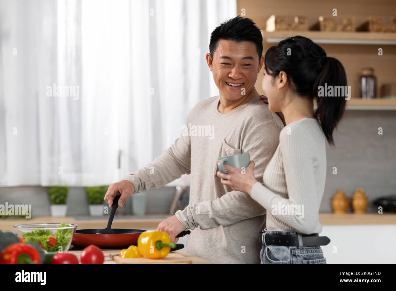 Homme chinois aimant cuisiner pour sa belle femme Banque D'Images