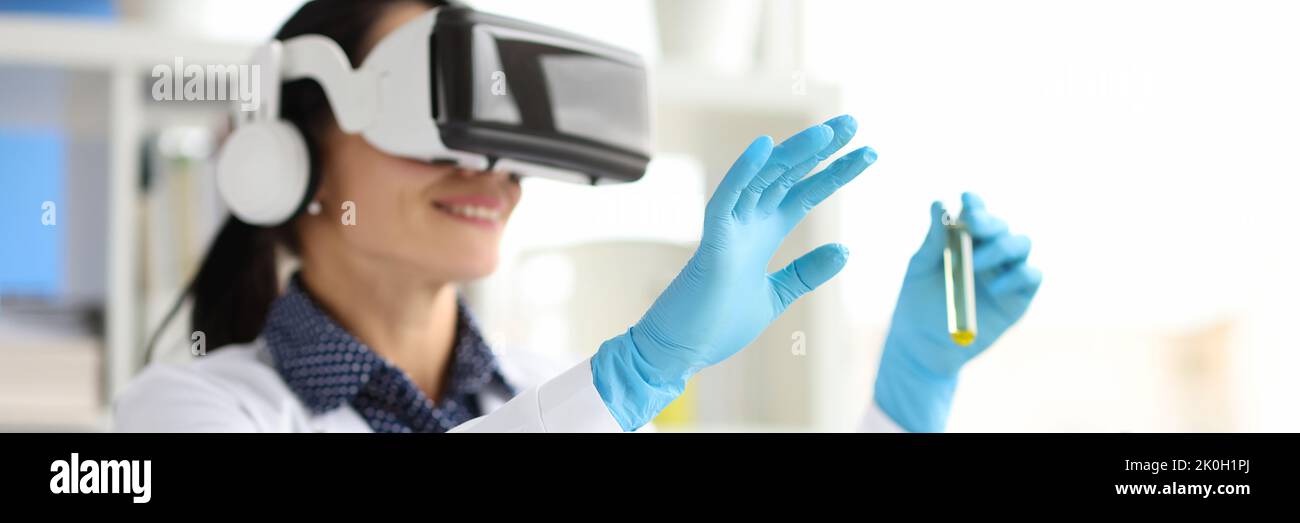 Médecin en lunettes virtuelles tient les tubes à essai en clinique Banque D'Images