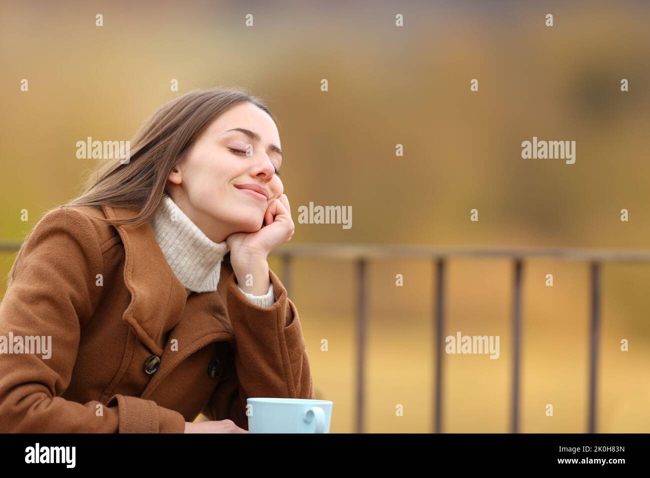 Femme détendue, assise sur une terrasse en hiver Banque D'Images