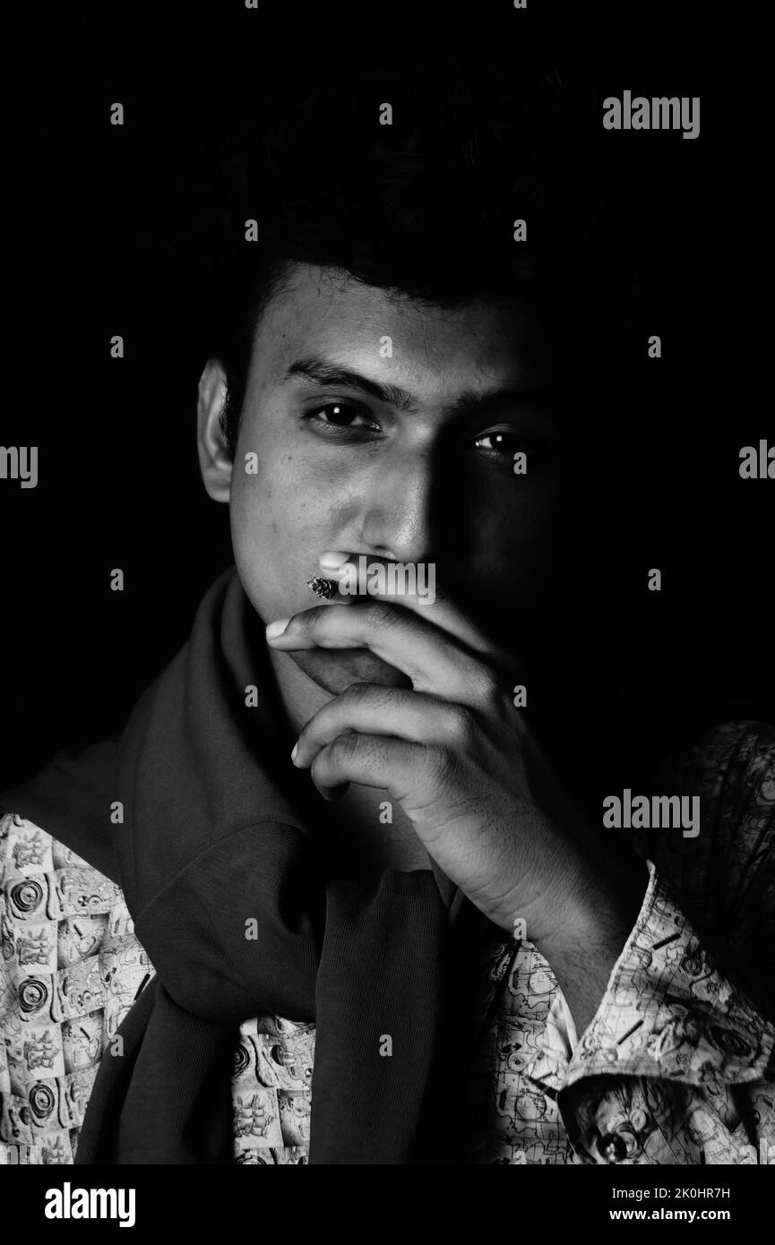 Portrait d'un homme d'Asie du Sud qui fume une cigarette en noir et blanc. Banque D'Images