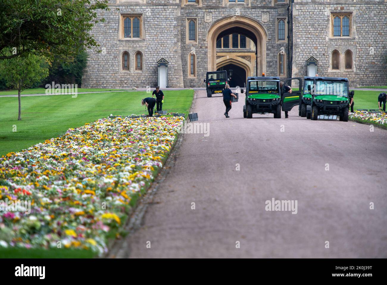 Windsor, Berkshire, Royaume-Uni. 12th septembre 2022. Les jardiniers du domaine de la Couronne posent les hommages floraux laissés par les gens sur les pelouses à l'intérieur du château de Windsor, près de la porte de Cambridge. Crédit : Maureen McLean/Alay Live News Banque D'Images