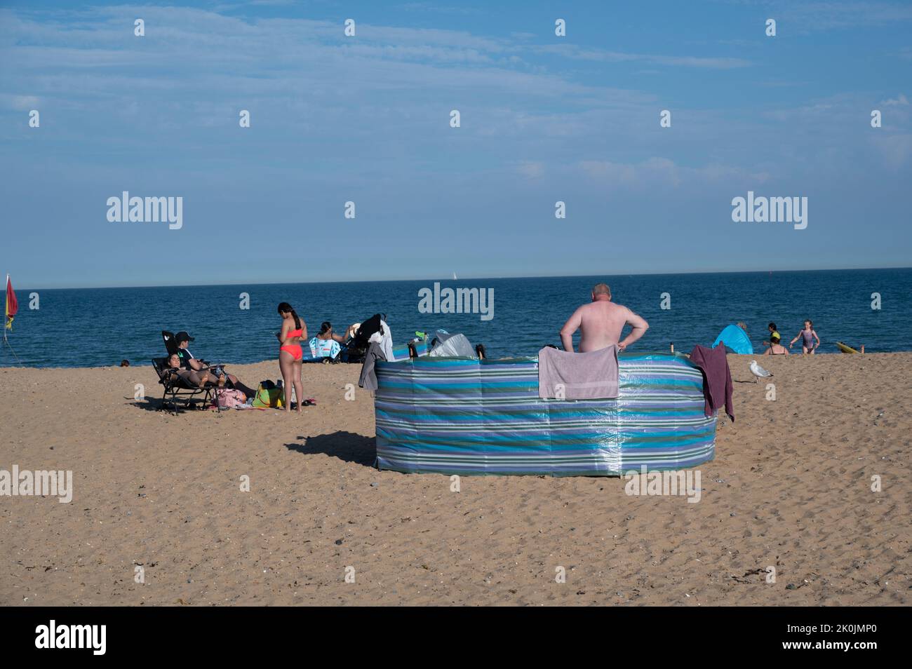 Ramsgate, Kent. Plage. Visiteurs sur le sable avec brise-vent. Banque D'Images