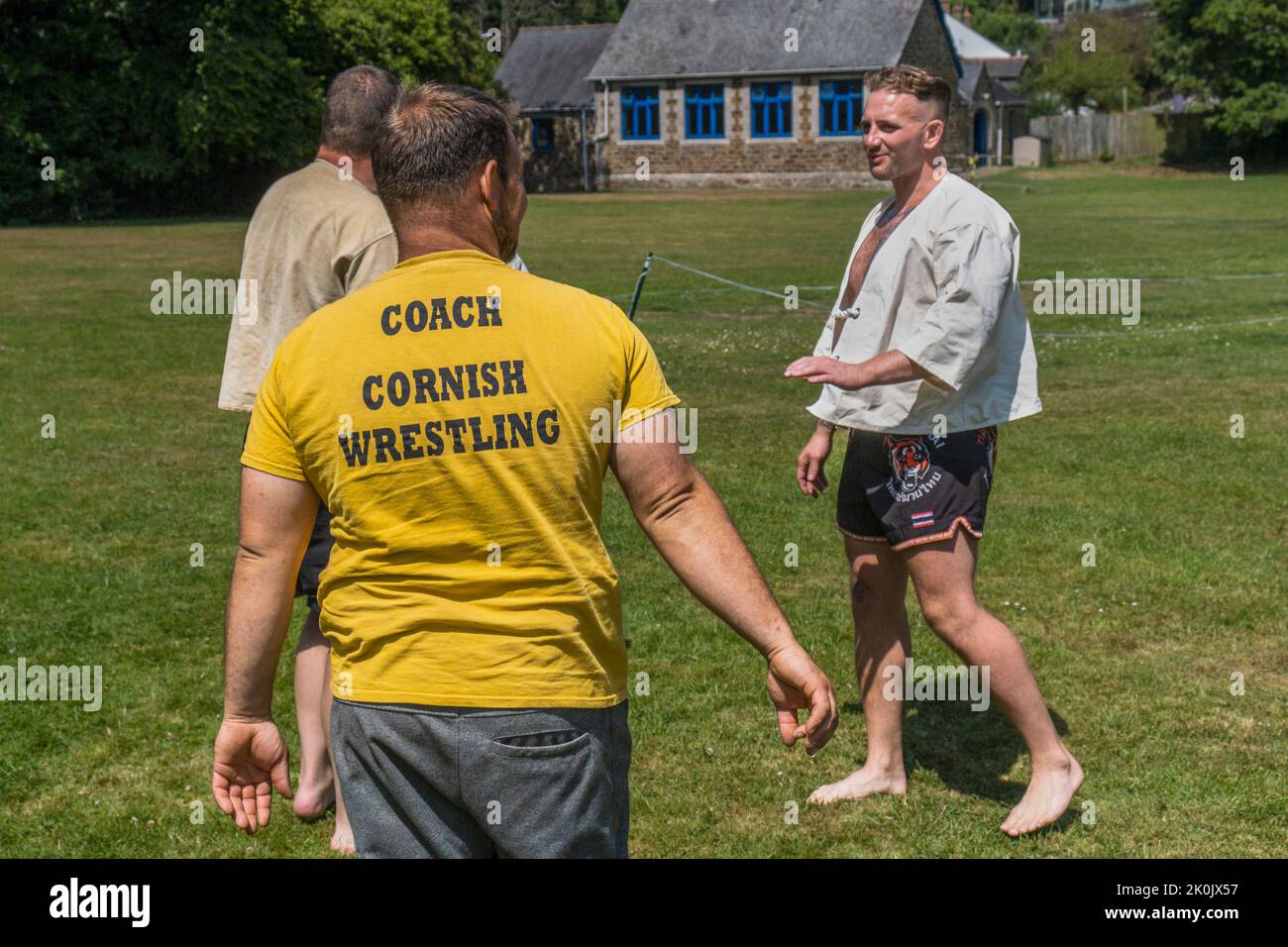 Un autocar expliquant les règles et les techniques de Cornish Wrestling avant le début du Grand Tournoi de Cornish Wrestling sur le village pittoresque Banque D'Images