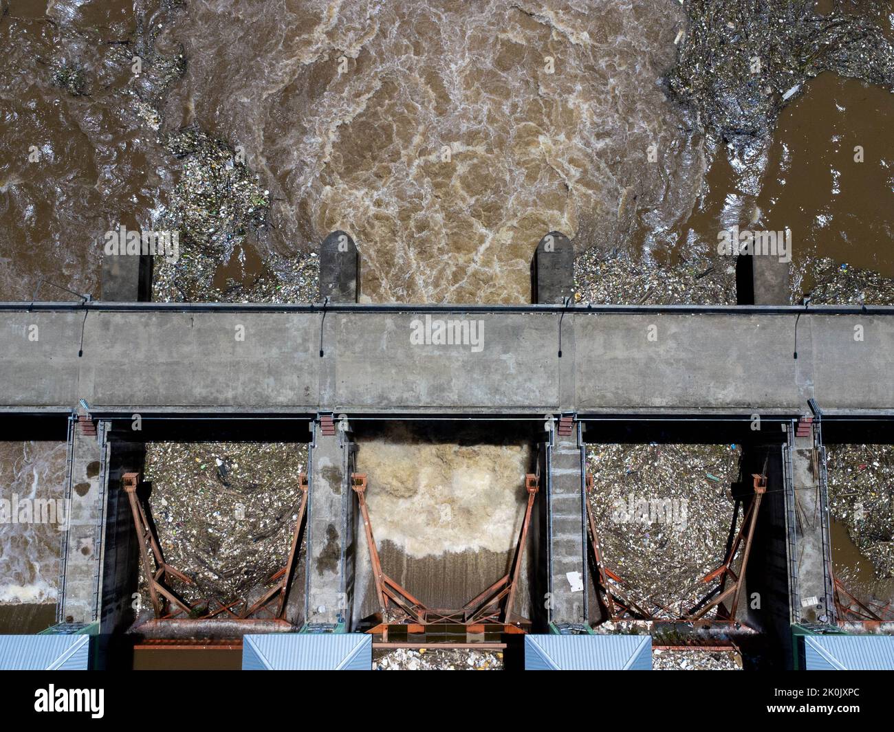 Vue aérienne de l'eau libérée par le canal de drainage du barrage en béton comme débordement dans la saison des pluies. Vue de dessus de l'eau de forêt brun trouble Banque D'Images