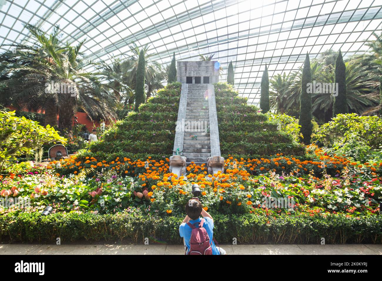 Un jeune garçon prenant en photo la reproduction de 4,5 m de haut de l'emblématique pyramide Chichén Itzá des Mayas. Jardins près de la baie, Singapour. Banque D'Images